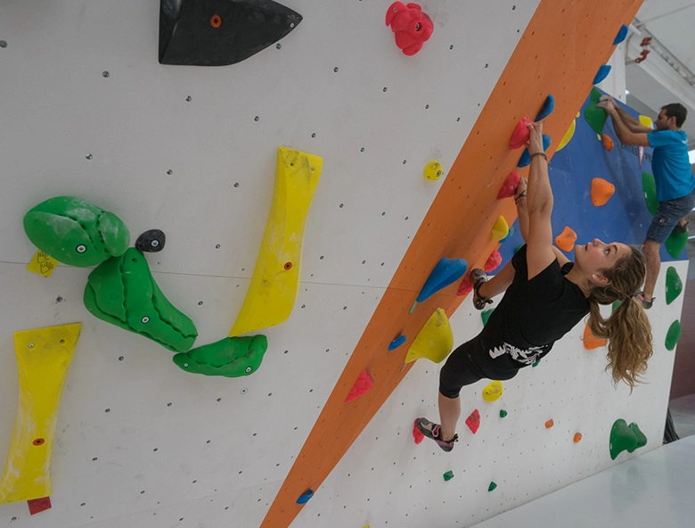mujer y hombre escalando en muro indoor